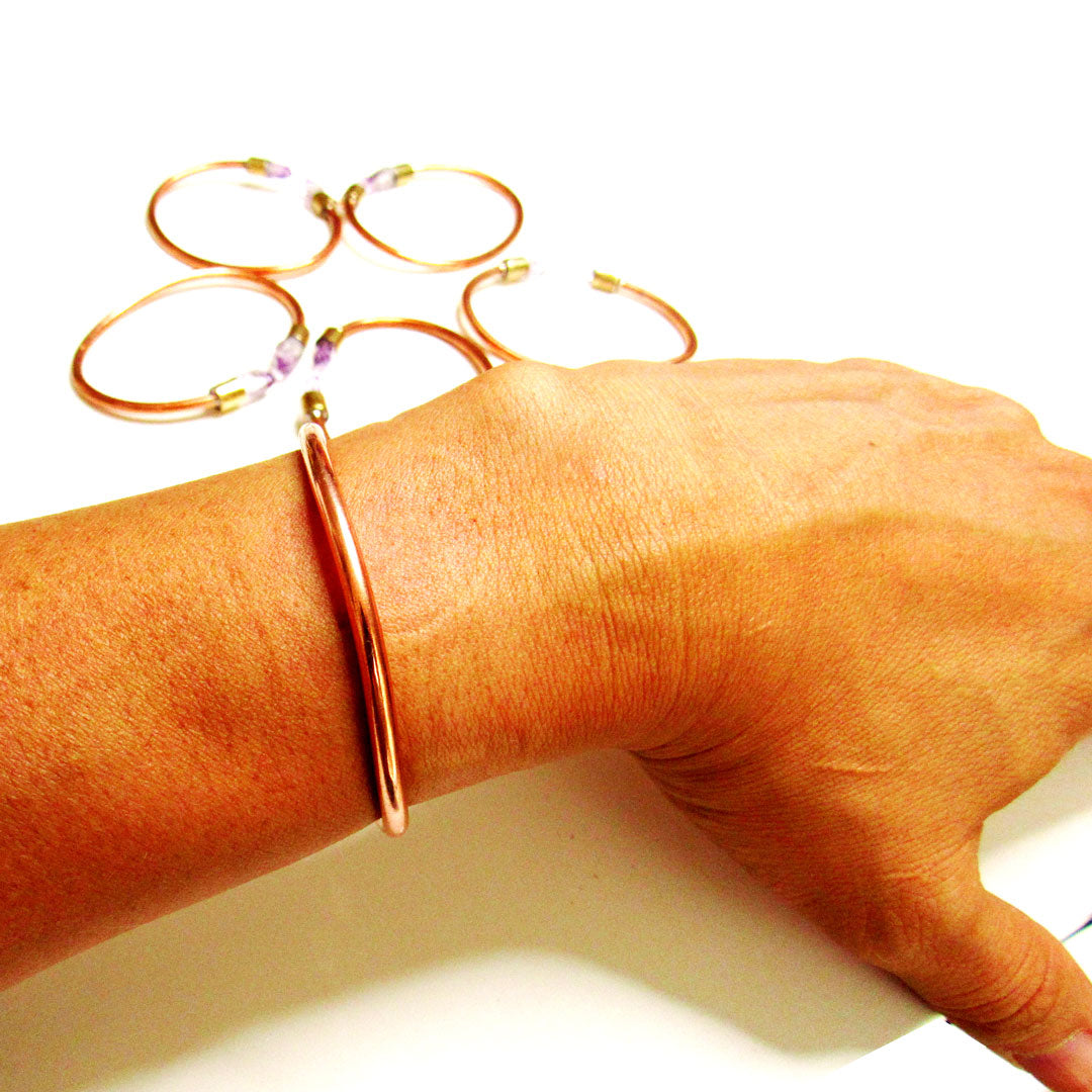 Pulsera de cobre con amatista en primer plano, acabado artesanal
