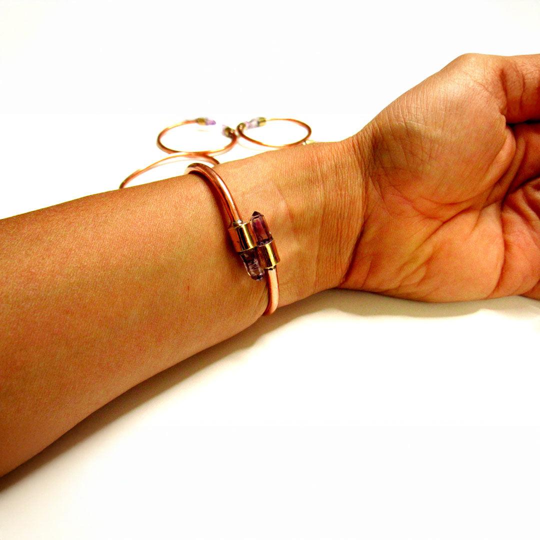 Amatista natural violeta engarzada en el extremo de la pulsera de cobre